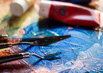 Close-up of artist palette with palette knives and paint tubes