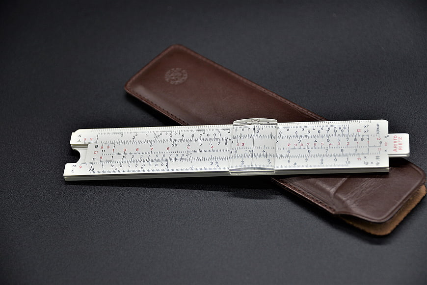 Vintage Ariti Slide Rule and Brown Leather Case on Dark Background