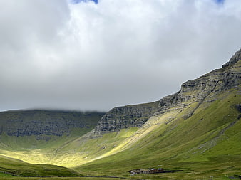 Dramatic Green Mountain Valley with Sunbeams and Clouds