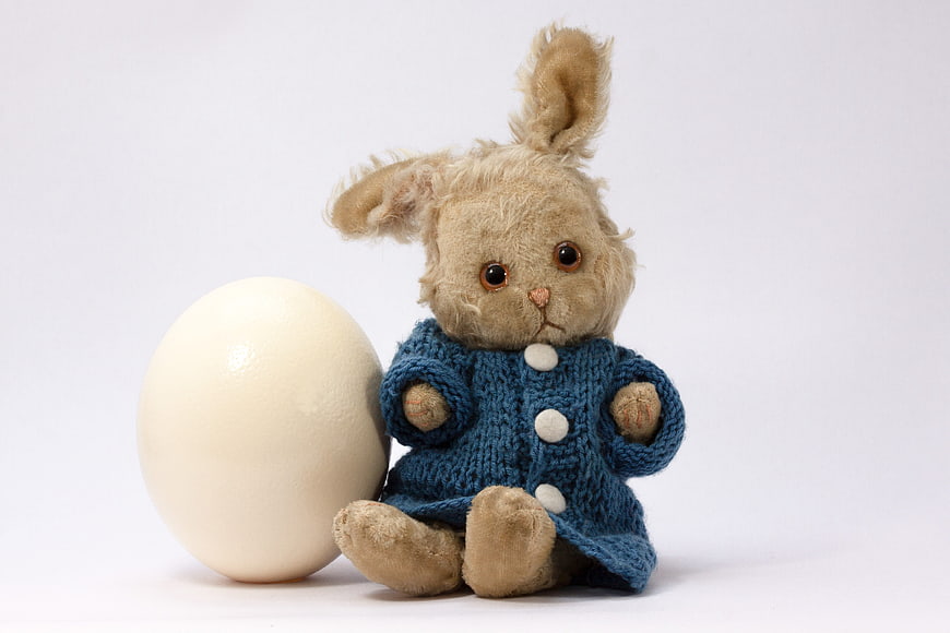 Sad Stuffed Bunny in Blue Sweater with Large White Egg