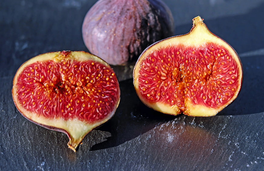 Fresh Ripe Figs Cut in Half on Dark Slate