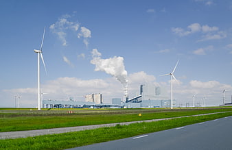Wind turbines and industrial power plant with smokestack