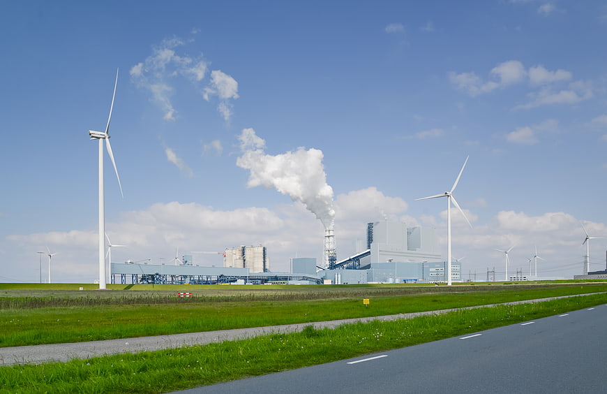 Wind turbines and industrial power plant with smokestack