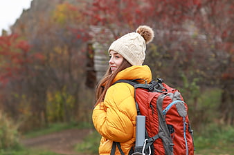 Happy Woman Hiking in Autumn Forest with Backpack
