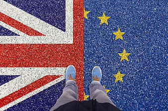 Person standing on painted UK and EU flags on asphalt