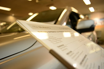 Subaru Outback price tag on car hood in dealership showroom