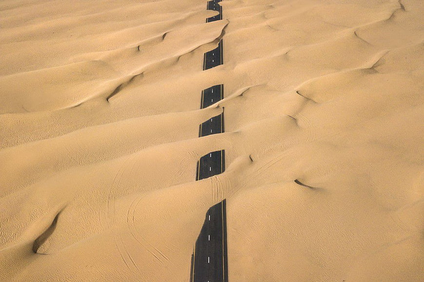 Aerial View of Desert Road Buried in Sand Dunes
