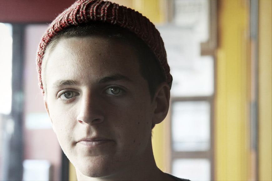 Portrait of Young Man in Red Knit Beanie Looking at Camera