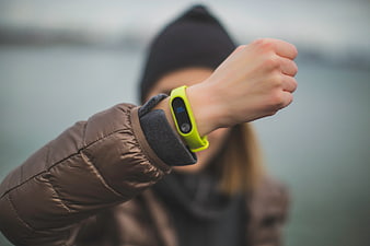 Woman checking fitness tracker on wrist outdoors