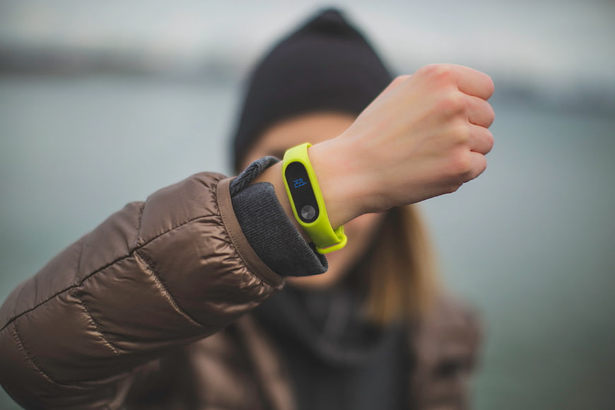 Woman checking fitness tracker on wrist outdoors