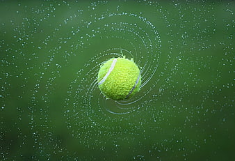 Tennis Ball Splashing into Green Water with Ripples
