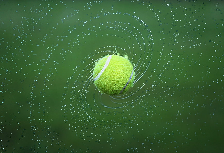 Tennis Ball Splashing into Green Water with Ripples