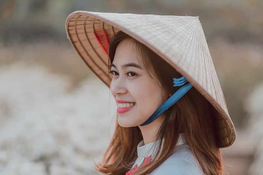 Smiling Asian Woman in Traditional Conical Hat