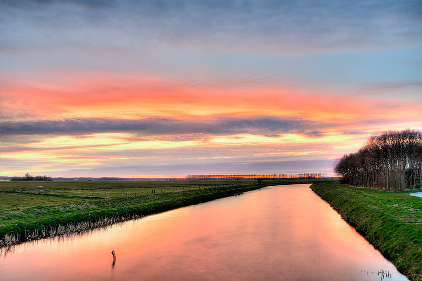 Serene Canal at Sunset with Vibrant Pink and Orange Sky