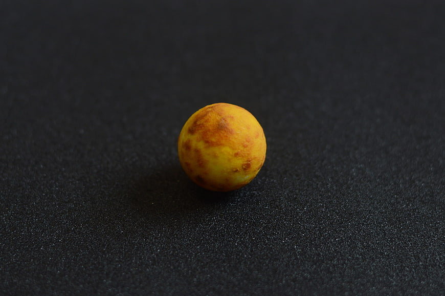 Yellow textured sphere on black background