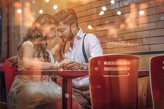 Romantic Couple Sharing Intimate Moment At Restaurant Table