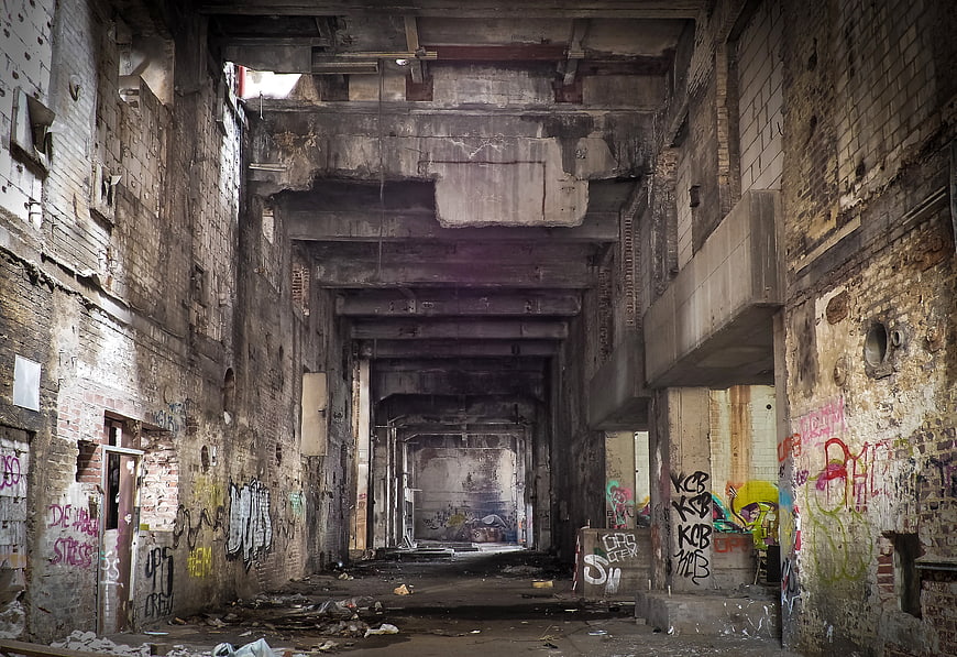 Abandoned industrial factory interior with graffiti and decay