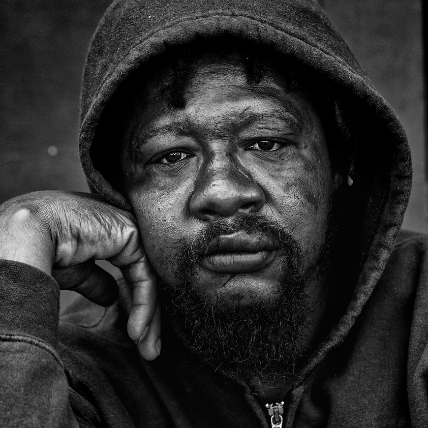Black and white portrait of a man in a hoodie