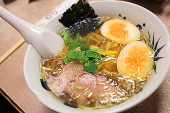 Close-up of Japanese ramen bowl with soft-boiled eggs and pork
