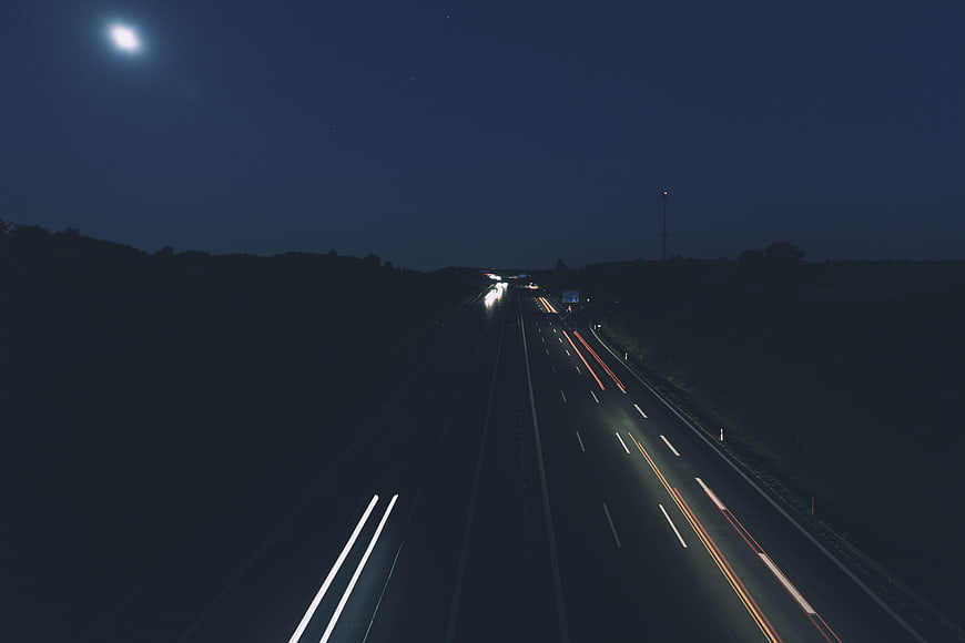 Night highway long exposure with light trails and moon