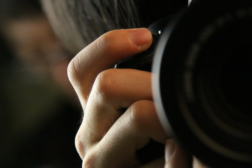 Close-up of hand holding camera lens