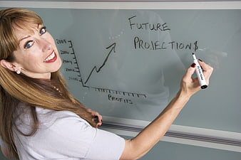 Smiling Business Woman Writing Future Projections on Whiteboard