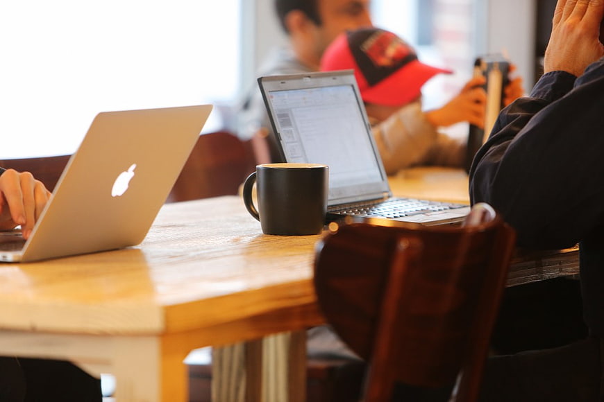 Freelancers working on laptops in a cafe