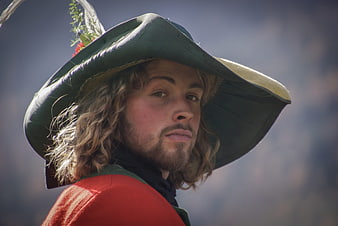 Portrait of a young man in a green hat and red tunic