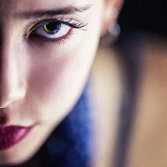 Close-up portrait of woman with striking eye and blue hair