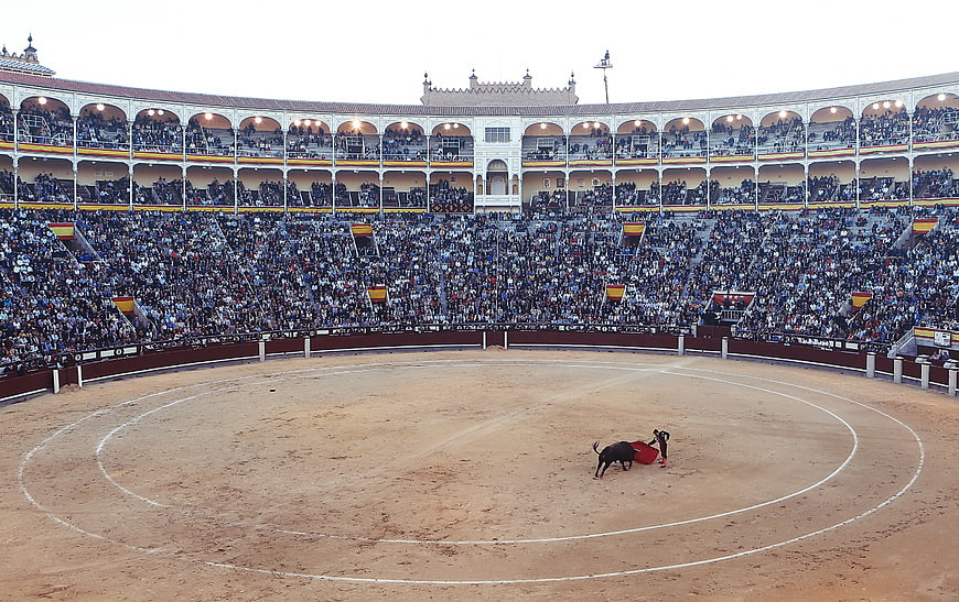Wide shot of bullfighting arena with matador and bull