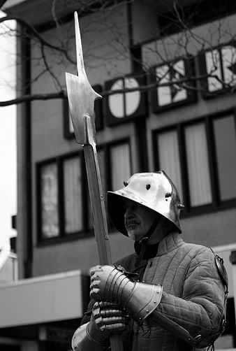 Medieval Knight in Armor Holding Halberd on Street