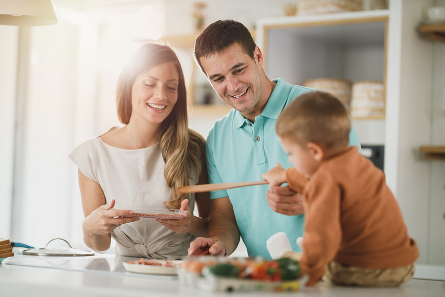 Happy family cooking together in bright modern kitchen