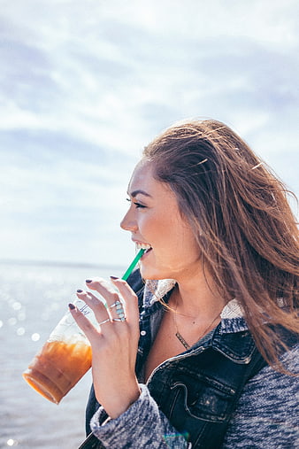 Happy Woman Drinking Iced Coffee by the Sea