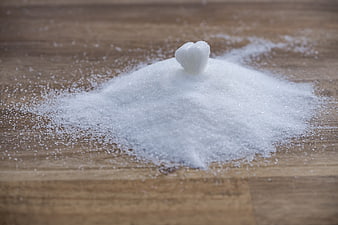 Heart-shaped sugar cube on pile of granulated sugar