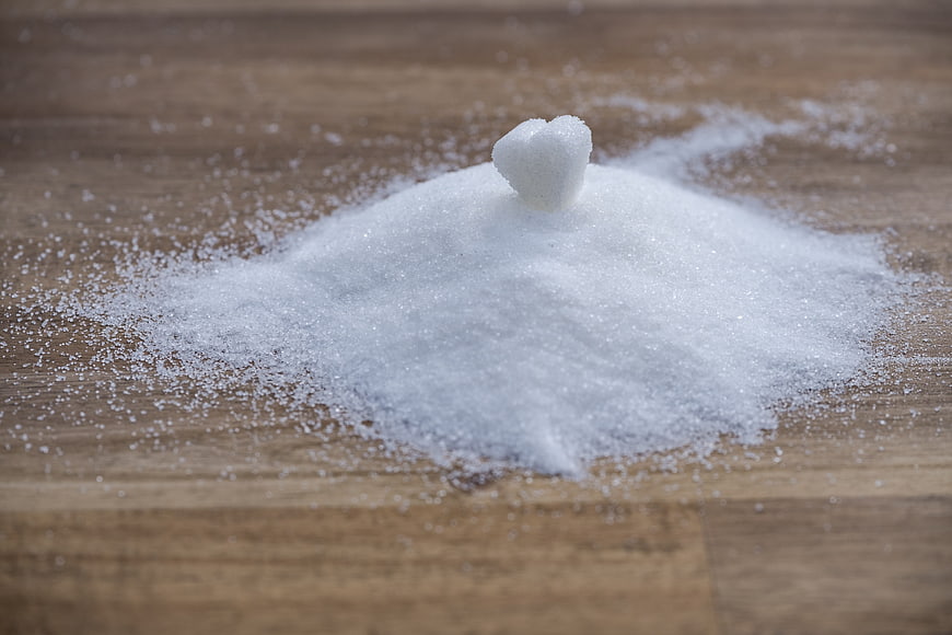 Heart-shaped sugar cube on pile of granulated sugar