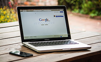 MacBook Pro with Google Search on Wooden Table Outdoors