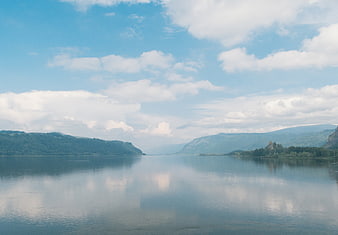 Serene Lake Landscape with Mountain Reflections and Cloudy Sky