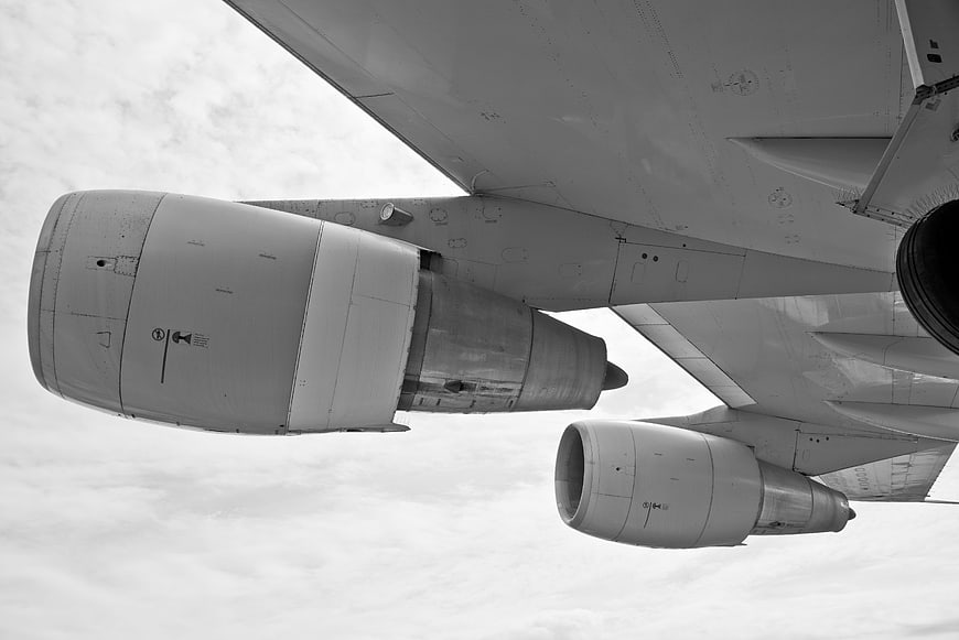 Black and white view of airplane engines and wings in flight
