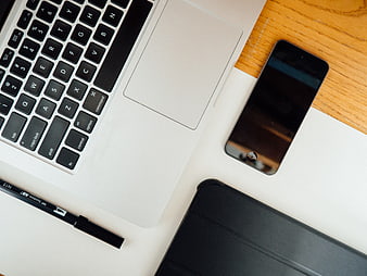 Flat lay of laptop, smartphone, and tablet on wooden desk