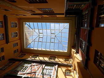 Low angle view of historic courtyard with glass roof and blue sky