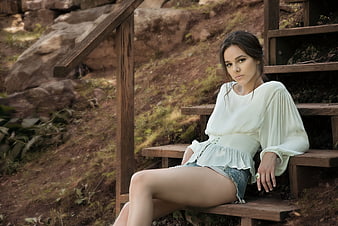 Young Woman Sitting on Wooden Steps in Nature