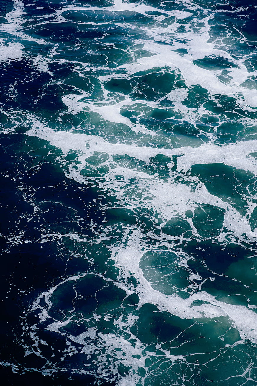 Aerial view of crashing ocean waves with white foam