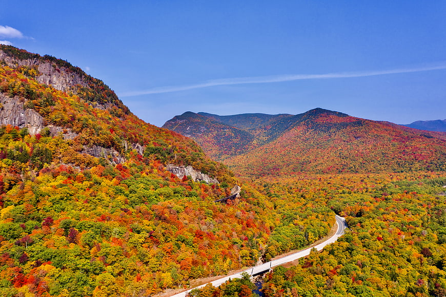 Aerial View of Winding Road Through Vibrant Autumn Mountains