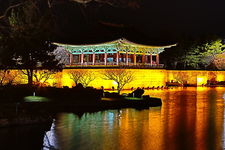 Illuminated Traditional Korean Pavilion at Night with Water Reflections