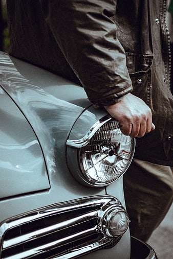Close-up of man's hand on vintage car headlight