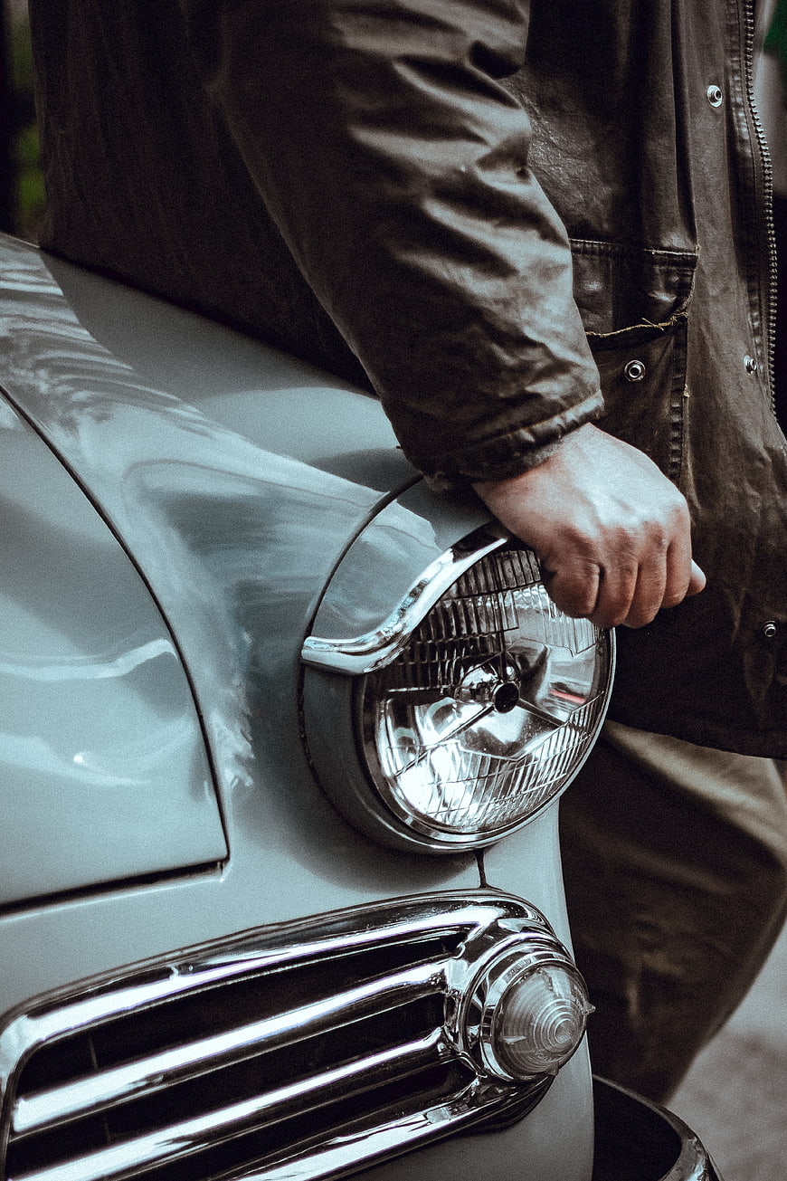 Close-up of man's hand on vintage car headlight