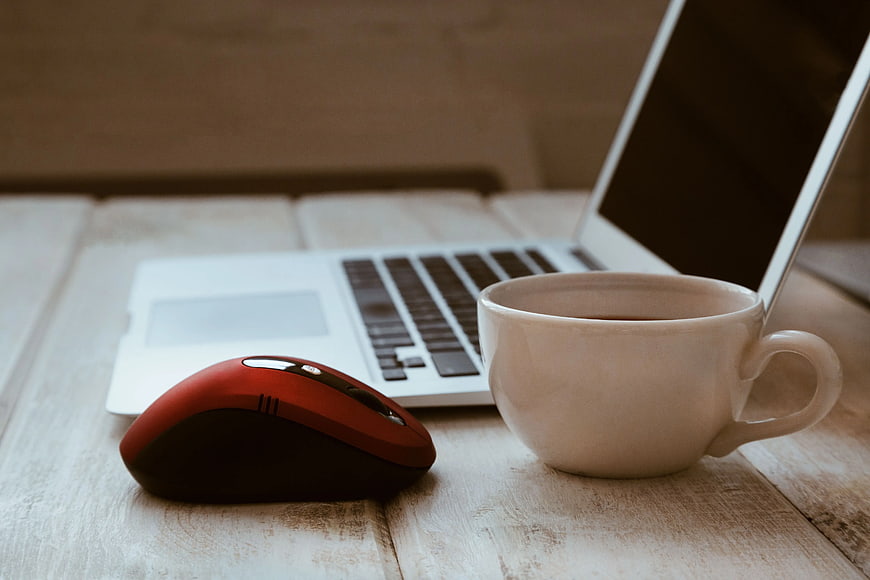 Red Mouse and Coffee Cup on Wooden Desk
