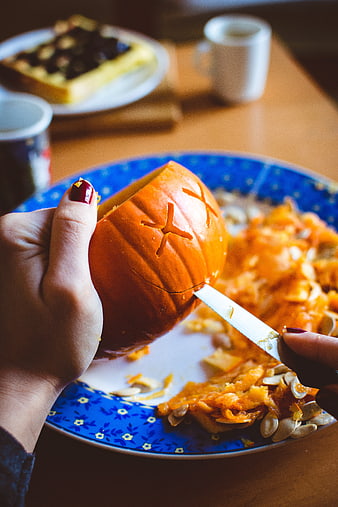 Hands Carving Small Halloween Pumpkin with Knife