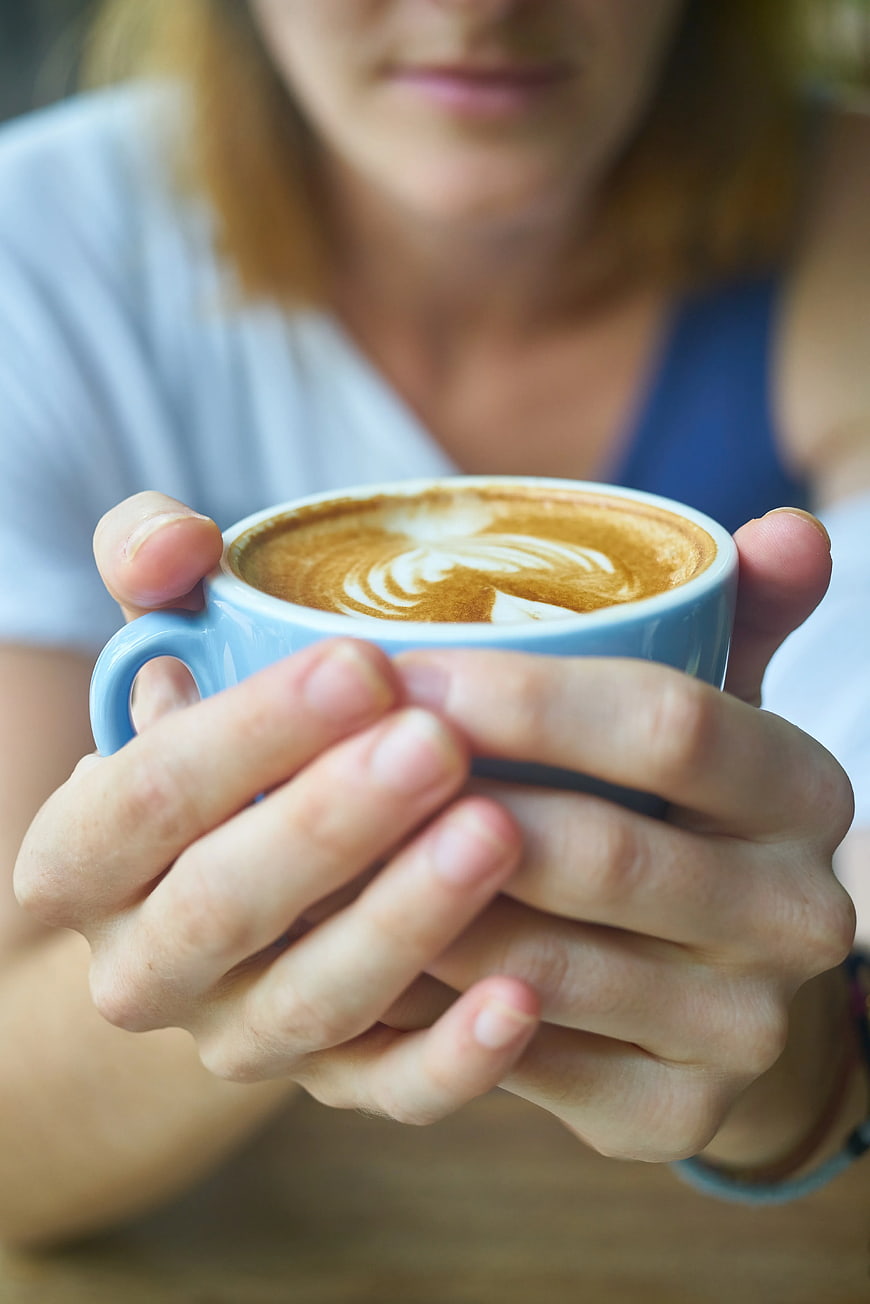 Woman Holding Blue Cup of Latte with Art
