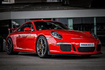 Red Porsche 911 GT3 991.1 parked in front of modern building